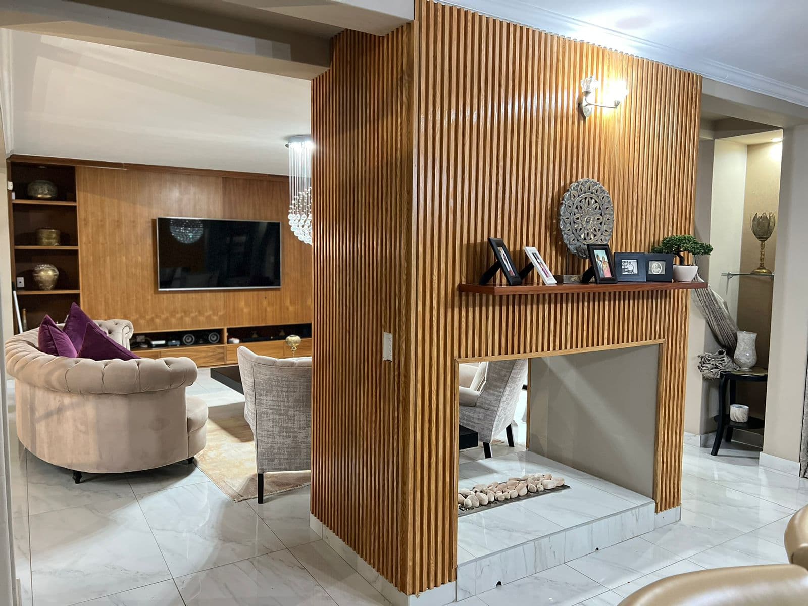 Wood-panelled TV wall, slat divider and fireplace nook